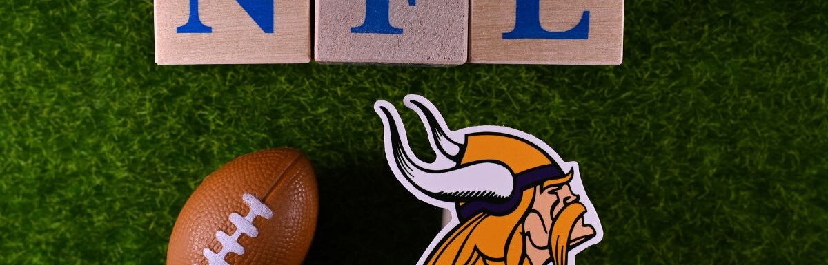 The emblem of the Minnesota Vikings football club on the green lawn of the stadium.
