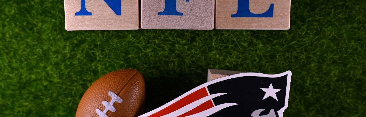 The emblem of the New England Patriots football club on the green lawn of the stadium.