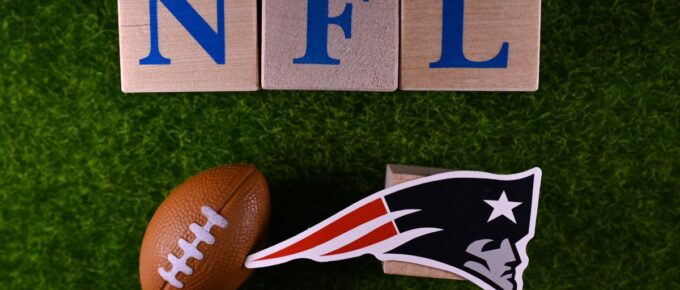 The emblem of the New England Patriots football club on the green lawn of the stadium.