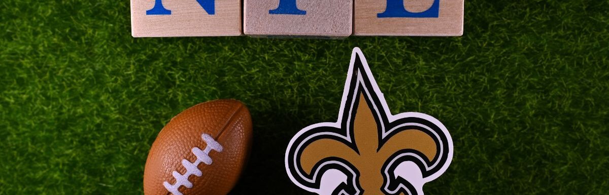 The emblem of the New Orleans Saints football club on the green lawn of the stadium.