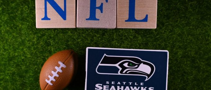 The emblem of the Seattle Seahawks football club on the green lawn of the stadium.