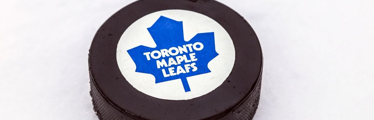 Toronto Maple Leafs logo on Ice hockey puck outdoors in snow.