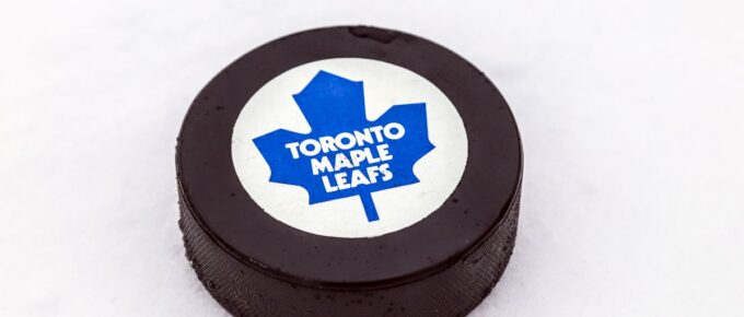 Toronto Maple Leafs logo on Ice hockey puck outdoors in snow.
