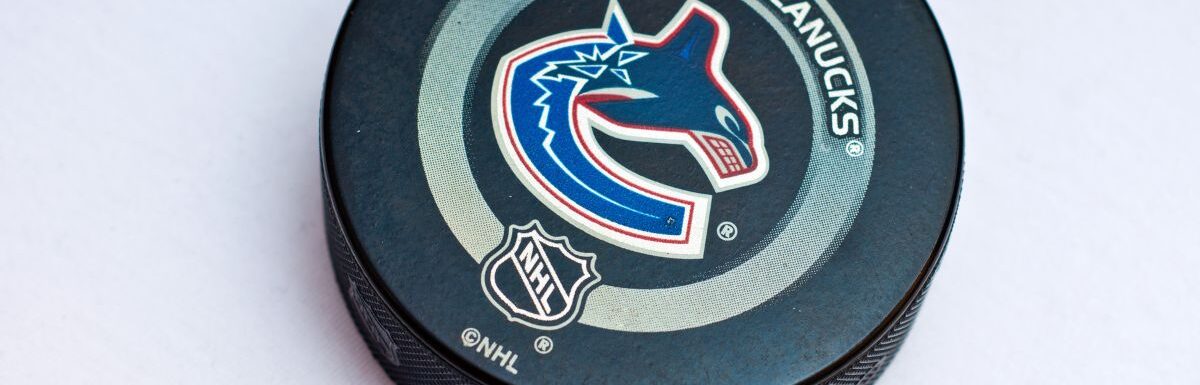 Official Vancouver Canucks game puck on the ice, product shot.