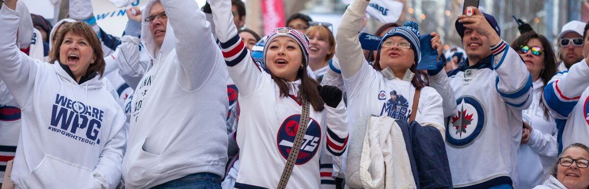 Fans wave for the TV cameras at the Winnipeg Whiteout street party during Game 1 of the Stanley Cup playoff game of the Winnipeg Jets versus the St. Louis Blues.