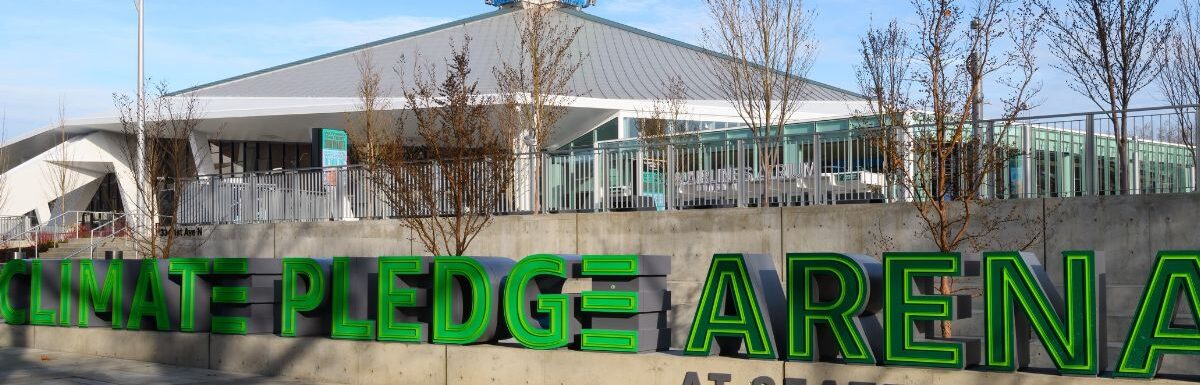 The Climate Pledge Arena in Seattle under a blue sky.