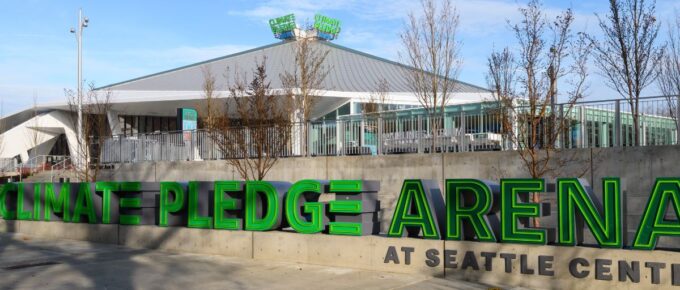 The Climate Pledge Arena in Seattle under a blue sky.