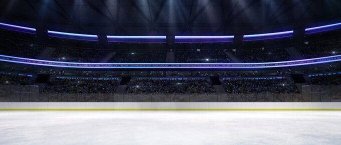 Empty ice rink arena indoor view illuminated by spotlights.