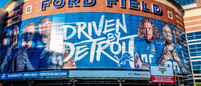 Horizontal, medium closeup of "Ford Field" Detroit Lions' football field stadium's exterior facade brand and logo signage on a sunny day.