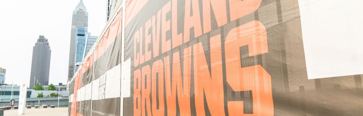 Cleveland Brown's Banner Closeup Leading To The Structural Cityscape Skyline Of Downtown Cleveland.