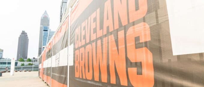 Cleveland Brown's Banner Closeup Leading To The Structural Cityscape Skyline Of Downtown Cleveland.