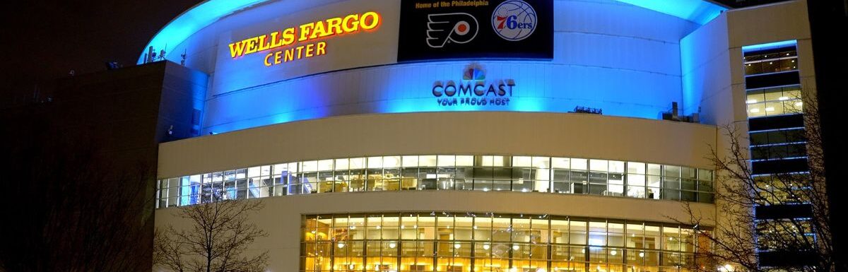 Wells Fargo Center with all the lights on outside at night.