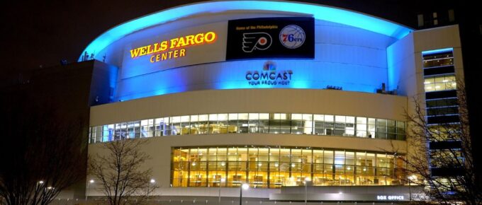 Wells Fargo Center with all the lights on outside at night.