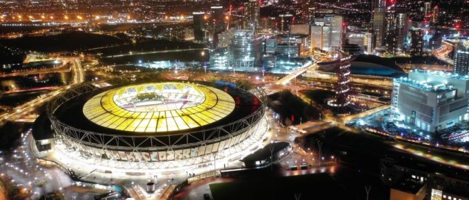 Aerial drone night shot of iconic illuminated London Stadium in Queen Elisabeth park, London, United Kingdom.