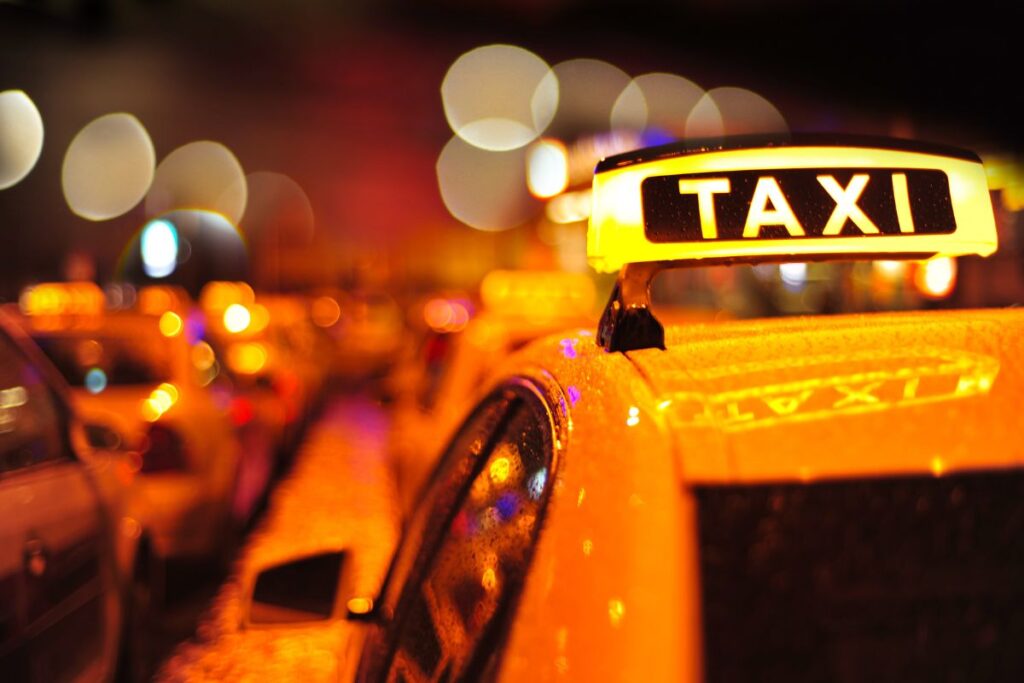 Yellow taxi with a taxi symbol above it.