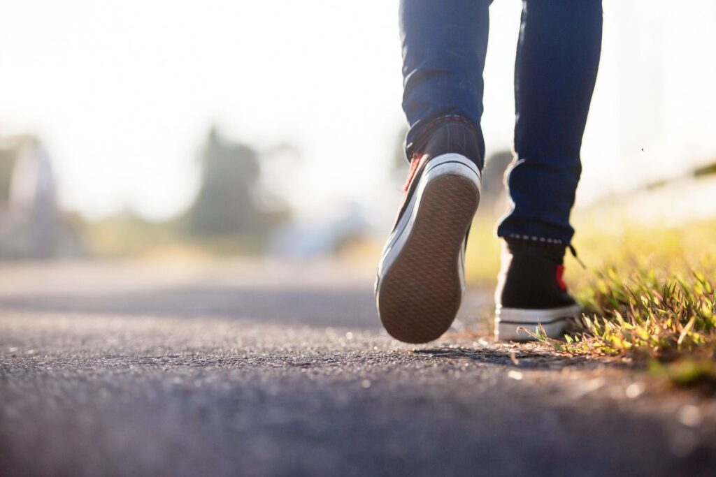 Close up of a person's shoes walking during the day.